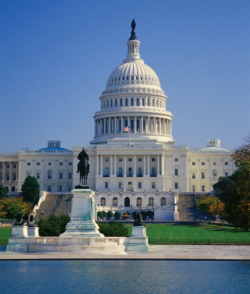 The U.S. Capitol dome viewed across the reflecting pool, framed by an equestrian memorial statue in the foreground.