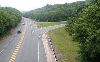 Aerial photograph of a two-lane road splitting into separate directions at a curved fork, illustrating a two-pass test-taking approach.