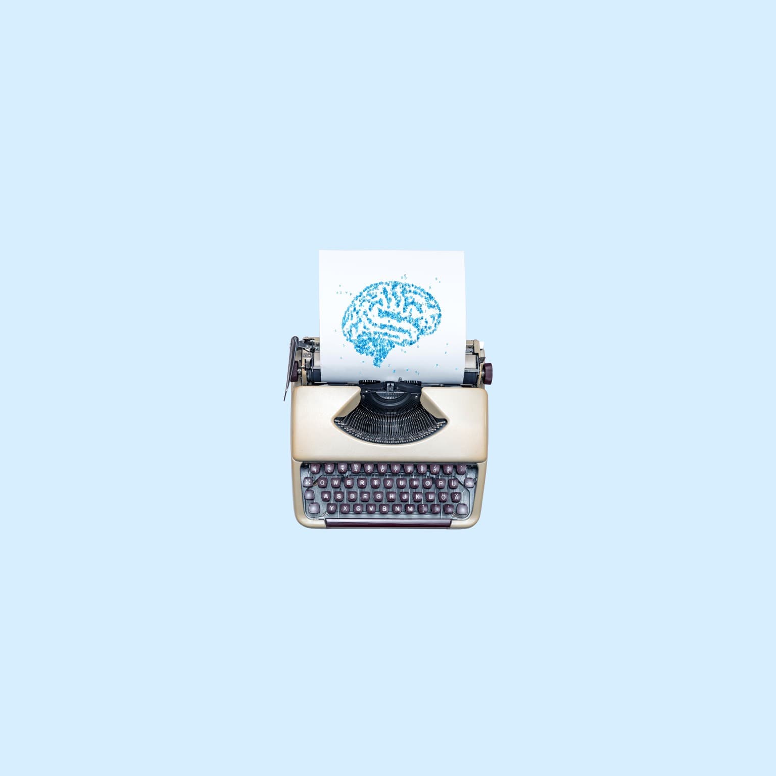 A vintage typewriter with a sheet of paper showing an image of a human brain formed from scattered letters.